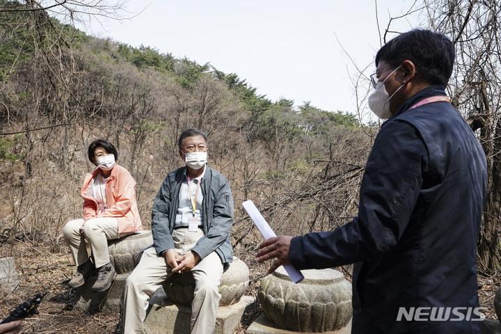 [서울=뉴시스] 문재인 대통령과 부인 김정숙 여사가 5일 서울 종로구 삼청안내소 출입구를 통과해 법흥사터에 도착, 김현모 문화재청장의 설명을 듣고 있다. 북악산 남측면은 오는 6일 전면 개방된다. (사진=청와대 제공) 2022.04.05. photo@newsis.com