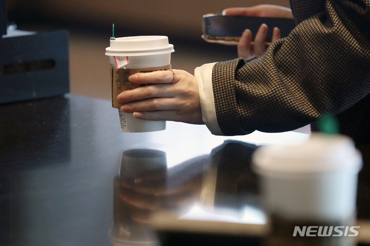 [서울=뉴시스] 서울 시내 한 프랜차이즈 커피 전문점에서 고객이 커피를 가져가고 있다. 2022.04.06. xconfind@newsis.com