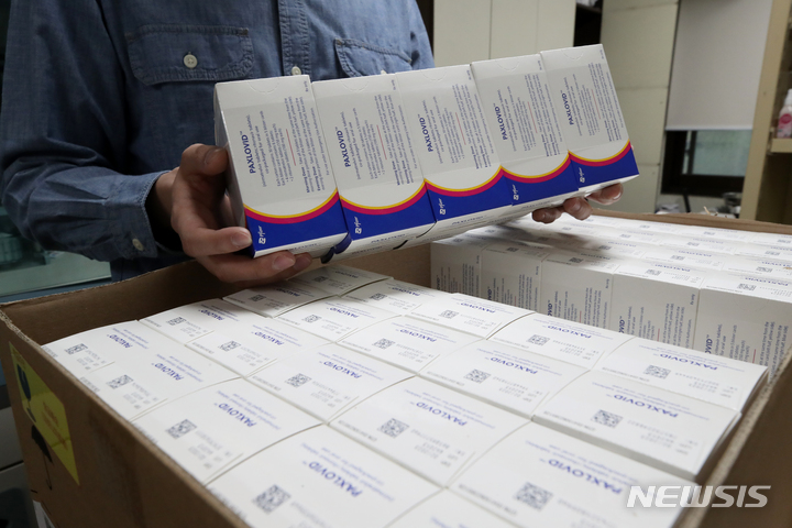 [서울=뉴시스] 김병문 기자 = 6일 오후 서울 성동구 보건소에서 직원이 코로나19 먹는 치료제 팍스로비드를 들어 보이고 있다. 질병관리청 중앙방역대책본부에 따르면 이날부터 전국 보건소에 코로나19 먹는 치료제를 공급해 처방에 활용한다. 이를 통해 요양병원과 요양시설, 정신병원 등에서는 보건소를 통해 먹는 치료제를 받을 수 있다. 2022.04.06. dadazon@newsis.com