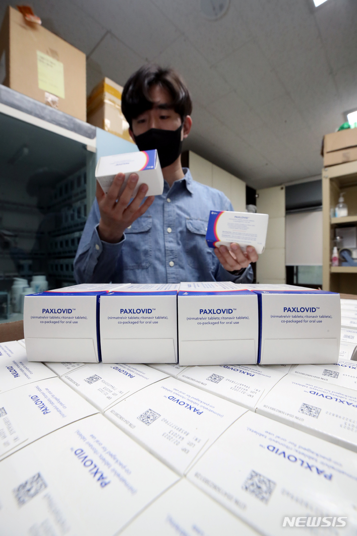 [서울=뉴시스] 김병문 기자 = 6일 오후 서울 성동구 보건소에서 직원이 코로나19 먹는 치료제 팍스로비드를 들어 보이고 있다. 질병관리청 중앙방역대책본부에 따르면 이날부터 전국 보건소에 코로나19 먹는 치료제를 공급해 처방에 활용한다. 이를 통해 요양병원과 요양시설, 정신병원 등에서는 보건소를 통해 먹는 치료제를 받을 수 있다. 2022.04.06. dadazon@newsis.com