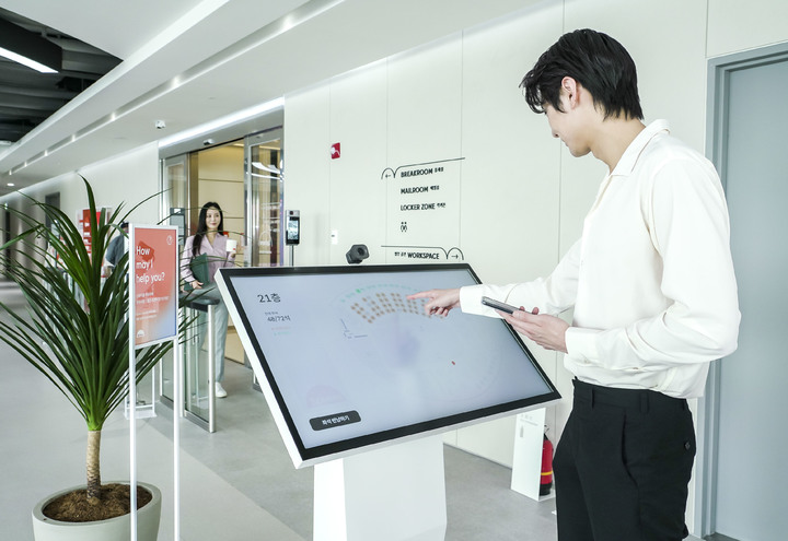 [서울=뉴시스]SK텔레콤 홍보모델이 거점오피스 스피어 신도림에서 AI 기반 얼굴인식 시스템을 활용해 좌석 예약을 하고 있는 모습. (사진=SK텔레콤 제공) 2022.04.07