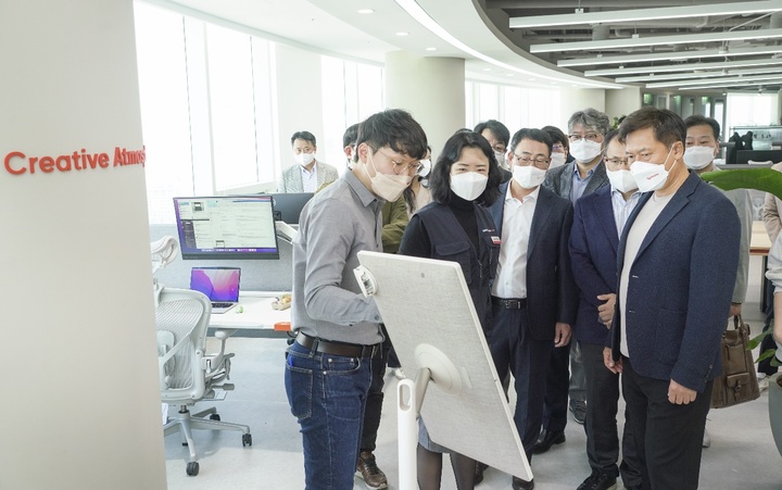 [서울=뉴시스]박정호 부회장(오른쪽 첫째줄)과 유영상 사장(왼쪽 세번째)이 거점오피스 'Sphere' 신도림을 둘러보고 있는 모습. (사진=SK텔레콤 제공) 2022.04.07