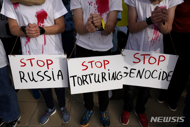 [니코시아=AP/뉴시스] 7일(현지시간) 키프로스 니코시아에서 양손을 묶은 우크라이나 사람들이 러시아 규탄 시위를 하고 있다. 이날 볼로디미르 젤렌스키 우크라이나 대통령은 키프로스 의회 화상 연설을 했다. 2022.04.08.