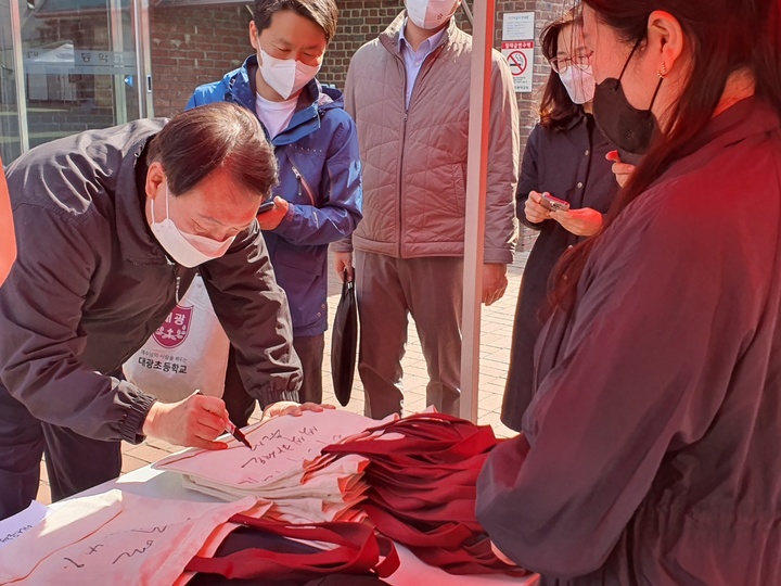 윤석열 대통령 당선인이 9일 모교인 서울 대광초를 방문해 에코백에 사인을 하고 있는 모습. (사진=윤 당선인 측 공) *재판매 및 DB 금지