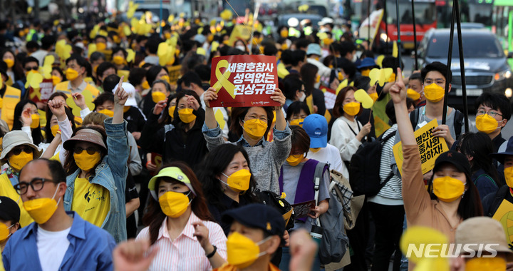 [서울=뉴시스] 추상철 기자 = 세월호 참사 8주기 국민대회 및 시민 행진이 열린 9일 오후 서울 중구 서울시의회 앞에 설치된 세월호기억공간 앞에서 행진을 마친 참가자들이 피켓을 들고 있다. 2022.04.09. scchoo@newsis.com