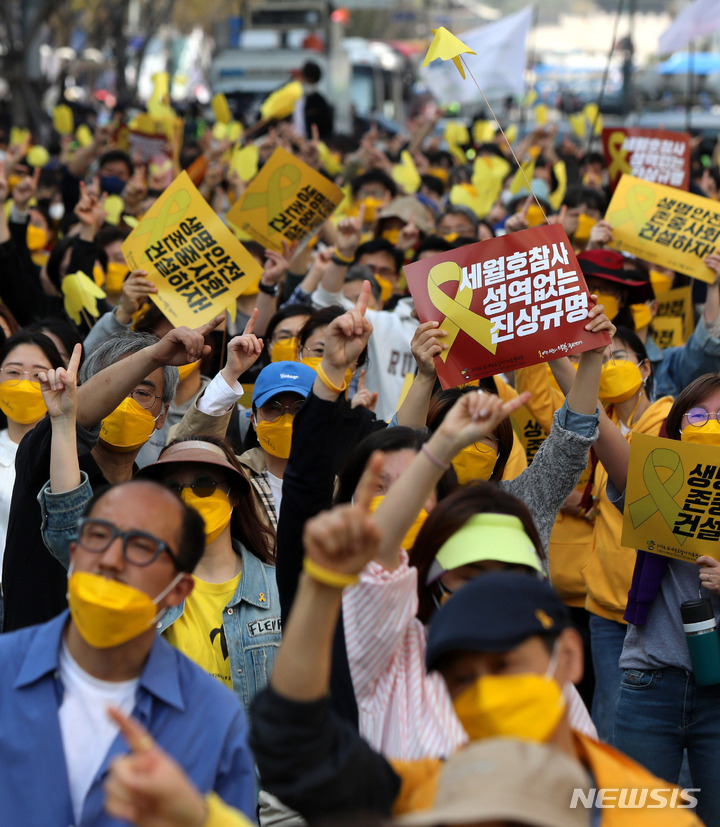 [서울=뉴시스] 추상철 기자 = 세월호 참사 8주기 국민대회 및 시민 행진이 열린 9일 오후 서울 중구 서울시의회 앞에 설치된 세월호기억공간 앞에서 행진을 마친 참가자들이 피켓을 들고 있다. 2022.04.09. scchoo@newsis.com
