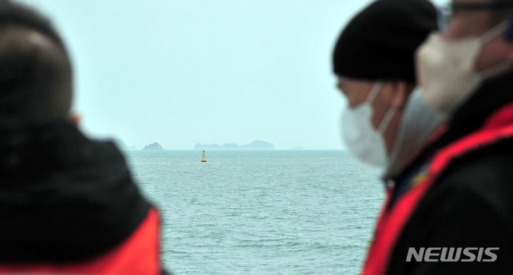 [진도=뉴시스] 이영주 기자 = 10일 오전 전남 진도군 동거차도 인근 세월호 참사 해역에서 사고 당시 구조에 참여했던 민간잠수사 강유성(52)씨가 동료들과 함께 맹골수도 위의 세월호 부표를 바라보고 있다. 2022.04.10. leeyj2578@newsis.com