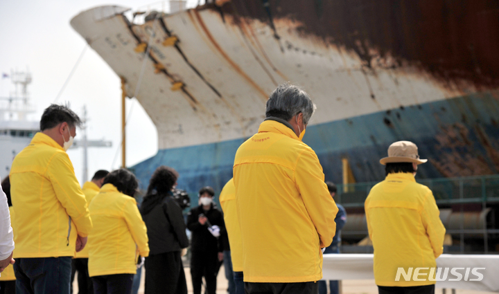 [목포=뉴시스] 이영주 기자 = 10일 오후 세월호 참사 유가족들이 전남 목포시 달동 목포신항만에 세워진 세월호 앞에서 묵념하고 있다. 2022.04.10. leeyj2578@newsis.com