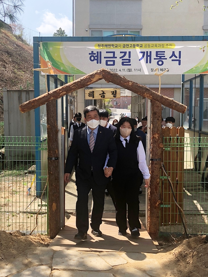 김명철 금천고등학교 교장(왼쪽)이 학생 손을 잡고 혜금길을 걷고 있다.2022.04.11.kipoi@newsis.com *재판매 및 DB 금지