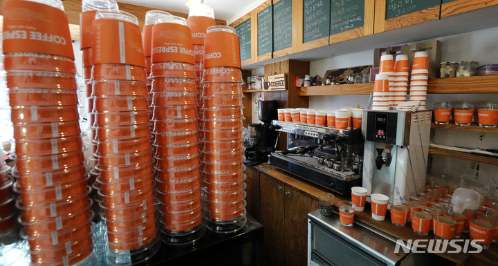 [서울=뉴시스] 이영환 기자 = 일회용 컵 보증금제 시행을 두달 앞둔 11일 오후 서울 시내의 한 카페에서 일회용 컵이 놓여 있다. 소비자는 보증금제 적용 매장에서 재활용 라벨이 붙은 일회용 컵에 담긴 음료를 살 때 보증금 300원을 내고 다 쓴 컵을 반납하면 되돌려받는다. 환경부는 지난달 17일까지 행정 예고된 고시 및 공고 제·개정안에 따라 105개 브랜드 매장 3만8000여곳에 보증금제가 적용된다. 이들은 커피·음료·제과제빵·패스트푸드 가맹본부나 사업자, 휴게·일반음식점, 제과점 영업사업자 중 2020년 말 기준으로 매장 100곳 이상을 운영하는 사업자다. 2022.04.11. 20hwan@newsis.com