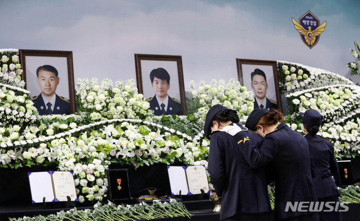 [부산=뉴시스] 하경민 기자 = 헬기 추락사고로 순직한 해양경찰관 3명의 합동 영결식이 열린 12일 오전 부산 강서구 강서실내체육관에서 동료 경찰관들이 헌화하고 있다. 2022.04.12. yulnetphoto@newsis.com