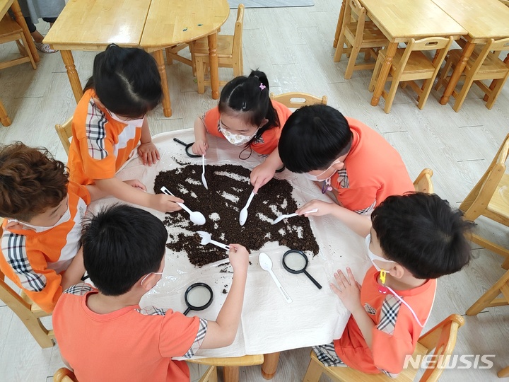 [성남=뉴시스]흙 속에 어떤 생물이 살고 있는지 배우고 직접 흙 속 생물 찾아보기를 체험하고 있다.