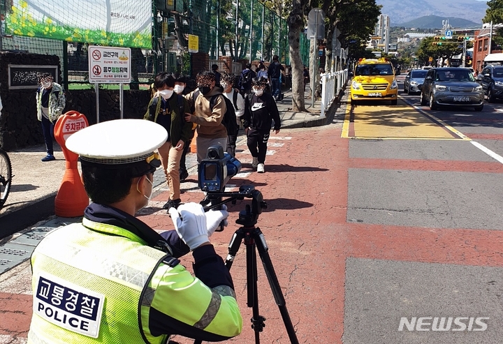 [제주=뉴시스] 스쿨존에서 캠코더 단속에 나선 제주경찰. (사진=제주경찰청 제공)