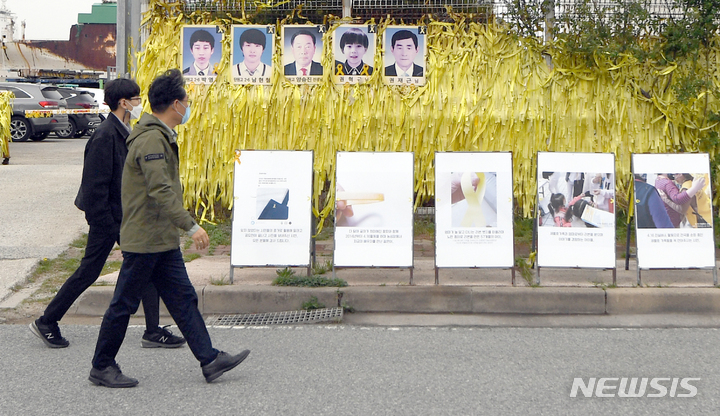 [목포=뉴시스] 류형근 기자 = 세월호 참사 8주기를 이틀 앞둔 14일 오전 전남 목포시 목포신항에서 추모객들이 철조망에 걸려있는 노란리본을 보고 있다. 2022.04.14. hgryu77@newsis.com