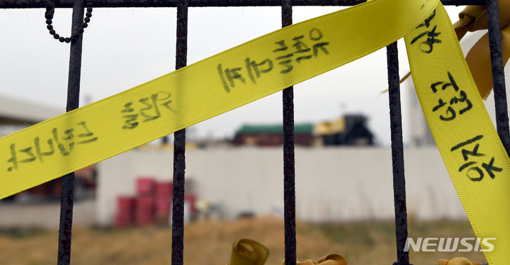 [목포=뉴시스] 류형근 기자 = 세월호 참사 8주기를 이틀 앞둔 14일 오전 전남 목포시 목포신항 철조망에 "잊지 않겠습니다" 노란리본이 걸려 있는 가운데 뒤편으로 육상 거치돼 있는 세월호가 희미하게 보이고 있다. 2022.04.14. hgryu77@newsis.com