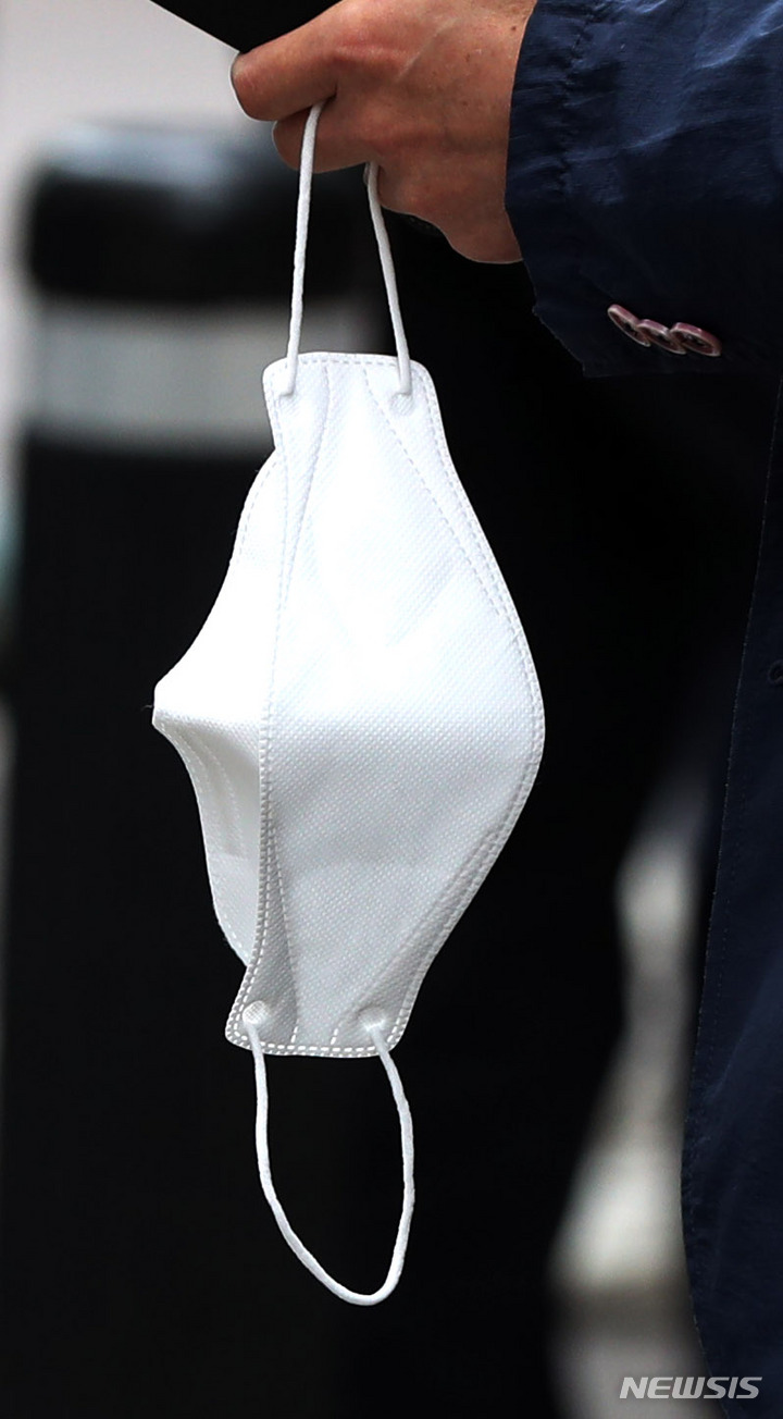 [서울=뉴시스] 추상철 기자 = 정부의 새 거리두기 조정안에 야외 마스크 착용 의무화 일부 해제 방안이 논의되고 있는 14일 오후 서울 도심에서 시민이 마스크를 손에 들고 있다. 2022.04.14. scchoo@newsis.com