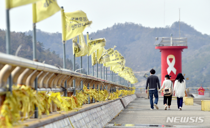 [진도=뉴시스] 류형근 기자 = 세월호 참사 8주기를 이틀 앞둔 14일 오후 전남 진도군 임회면 진도항(팽목항) 방파제에서 추모객들이 8년전 희생자들을 기다리며 설치됐던 노란리본과 깃발·조형물을 보며 추모하고 있다. 2022.04.14. hgryu77@newsis.com