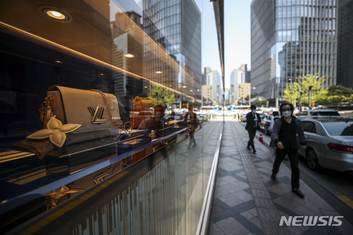 [서울=뉴시스] 지난해 4월 서울시내 백화점 앞에서 시민들이 이동하고 있다. 