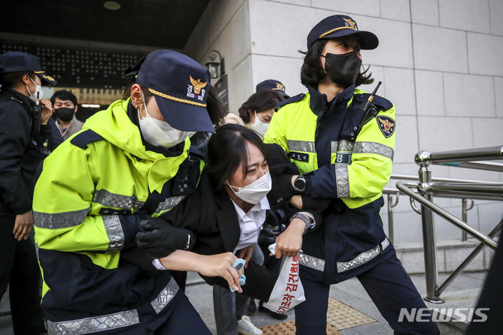 [서울=뉴시스] 정병혁 기자 = 대학생진보연합 소속 대학생들이 15일 오후 서울 서초구 대검찰청 기자실에서 도이치모터스 주가조작 관련 수사촉구, 한동훈 법무부 장관 지명을 규탄하는 기습시위를 벌이다 경찰에 연행되고 있다. 2022.04.15. jhope@newsis.com