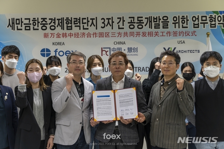 포엑스무역관협동조합 김승수 회장이 화상회의를 통해 중국 중원혜창 주금휘 회장과 미국LA YKA건축사무소 김용원 대표와 새만금한중경제협력단지 3자 간 공동개발을 위한 업무협약서에 서명하고 기념 촬영을 하고 있다. (사진=포엑스 제공)