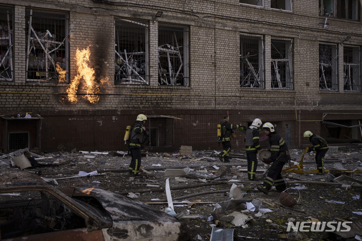 [하르키우(우크라이나)=AP/뉴시스] 하르키우 시내에서 4월 6일 러시아군의 미사일 공격으로 불이 붙은 주택의 진화에 힘쓰고 있는 소방대원들.  