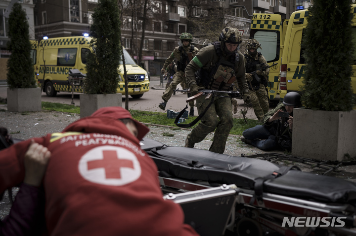 [하르키우=AP/뉴시스] 17일(현지시간) 우크라이나 하르키우 시내에서 우크라이나 군인들이 러시아군의 포성에 엄폐할 곳을 찾아 황급히 대피하고 있다. 2022.04.18.