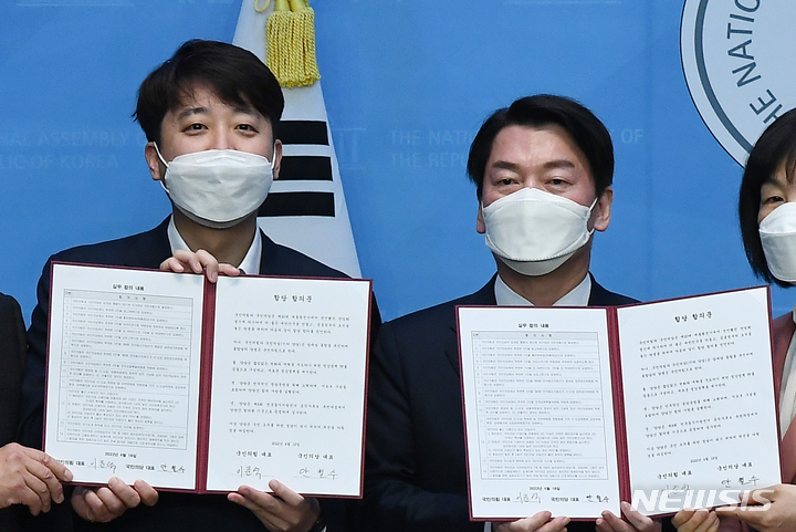 [서울=뉴시스] 최진석 기자 = 이준석(왼쪽) 국민의힘 대표와 안철수 국민의당 대표가 18일 서울 여의도 소통관에서 합당 기자회견을 하며 합당 합의문을 들어 보이고 있다. 합당 후 당명은 국민의힘이라고 발표했다. (공동취재사진) 2022.04.18. photo@newsis.com