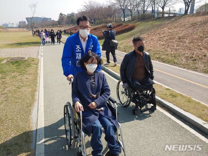 [오산=뉴시스] 더불어민주당 조재훈 오산시장 예비후보가 장애인분들과 함께 오산천변을 걷고 있다. 