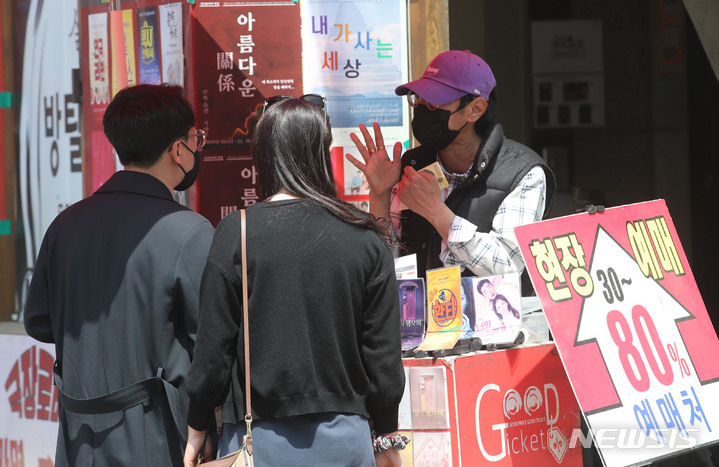 [서울=뉴시스] 권창회 기자 = 사회적 거리두기 해제 이튿날인 19일 오후 서울 종로구 대학로에서 시민들이 연극을 보기 위해 티켓 예매를 하고 있다. 2022.04.19. kch0523@newsis.com