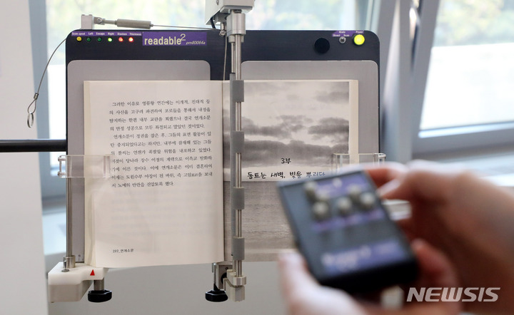 [서울=뉴시스] 추상철 기자 = 19일 오후 서울 서초구 국립장애인도서관에서 오현정 지원협력과 주무관이 전동페이지터너에 대한 설명을 하고 있다. 2022.04.20. scchoo@newsis.com