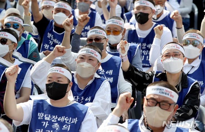 [서울=뉴시스] 김병문 기자 = 발달장애인과 가족 550여 명이 19일 오후 서울 종로구 청와대 인근에서 전국장애인부모연대 주최로 열린 발달장애인 24시간 지원 체계 구축을 위한 1박2일 집중 결의대회에서 단체 삭발을 한 뒤 구호를 외치고 있다. 2022.04.19. dadazon@newsis.com