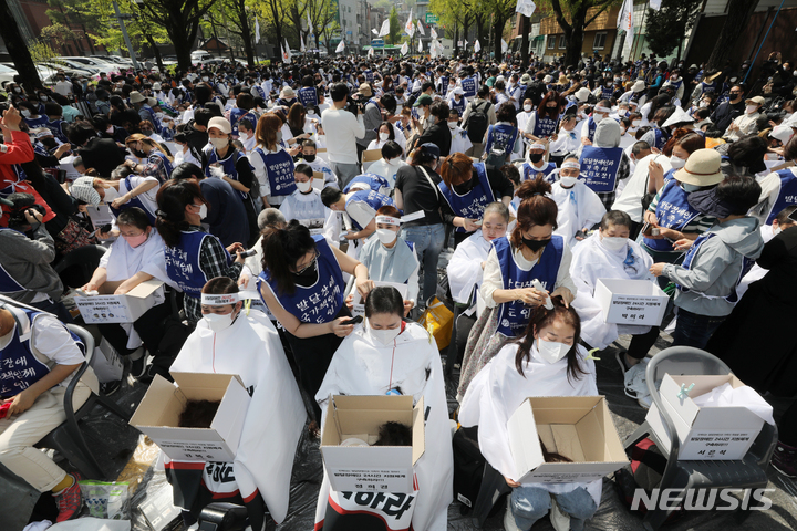 [서울=뉴시스] 김병문 기자 = 발달장애인과 가족 550여 명이 지난 19일 오후 서울 종로구 청와대 인근에서 전국장애인부모연대 주최로 열린 발달장애인 24시간 지원 체계 구축을 위한 1박2일 집중 결의대회에서 단체 삭발을 하고 있다. 2022.04.19. dadazon@newsis.com