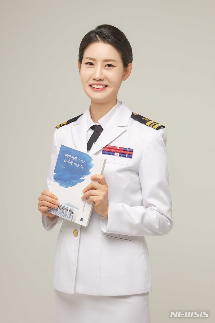 해군 제1함대 공보정훈실장인 박주미 소령이 책을 들고 포즈를 취하고 있다. (사진=해군 제1함대사령부 제공)