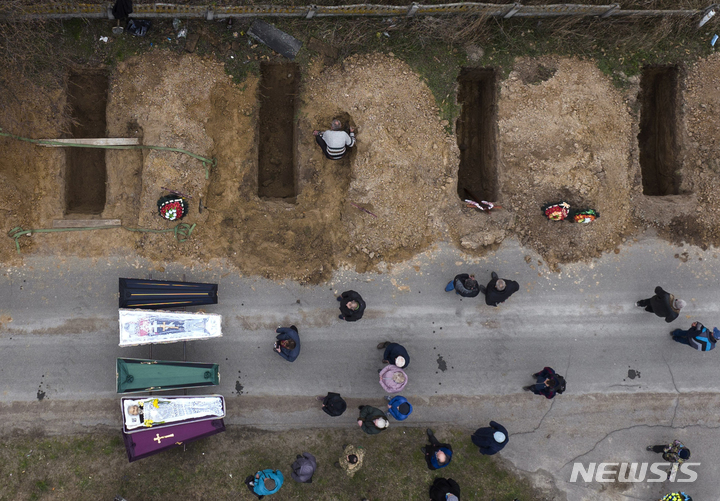 [부차=AP/뉴시스] 지난달 20일(현지시간) 우크라이나 부차에서 러시아군 점령 기간 중 숨진 민간인 4명에 대한 장례식이 열리고 있다. 2022.05.13.