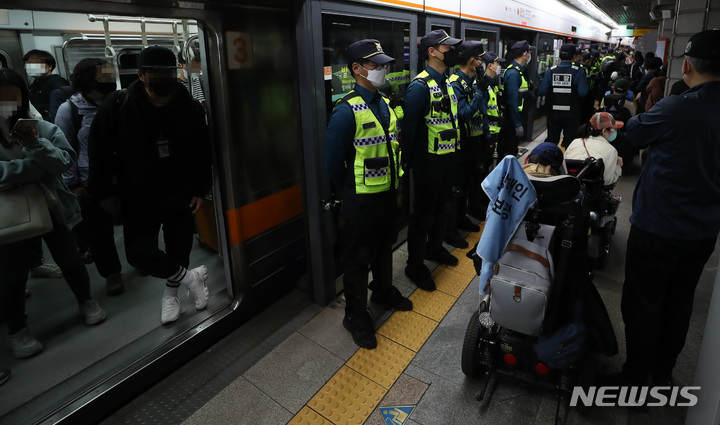 [서울=뉴시스] 이영환 기자 = 전국장애인차별철폐연대(전장연) 회원들이 21일 서울 종로구 지하철3호선 경복궁역에서 '출근길 지하철 타기' 시위를 하고 있다. 전장연에 따르면 시위는 이날 오전 7시부터 서울 지하철 3호선 경복궁역, 2호선 시청역, 5호선 광화문역 등 3곳에서 동시 진행된다. 2022.04.21. 20hwan@newsis.com