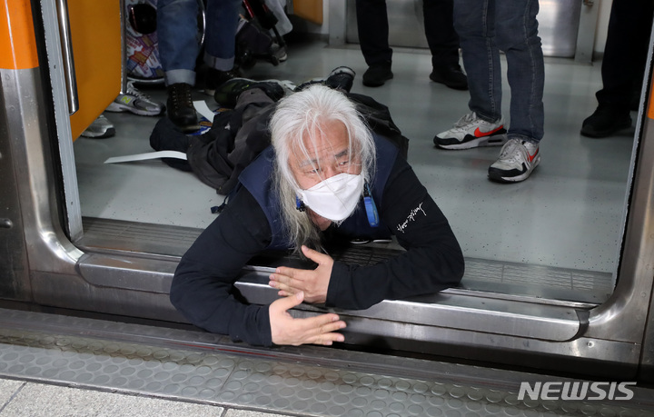 [서울=뉴시스] 이영환 기자 = 박경석 전국장애인차별철폐연대(전장연) 공동대표와 회원들이 지난달 21일 서울 종로구 지하철3호선 경복궁역에서 '출근길 지하철 타기' 시위를 하고 있다. 전장연에 따르면 시위는 이날 오전 7시부터 서울 지하철 3호선 경복궁역, 2호선 시청역, 5호선 광화문역 등 3곳에서 동시 진행된다.&nbsp; 2022.04.21. 20hwan@newsis.com