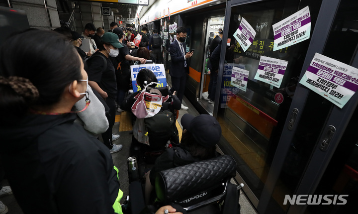 [서울=뉴시스] 이영환 기자 = 전국장애인차별철폐연대(전장연) 회원들이 21일 서울 종로구 지하철3호선 경복궁역에서 '출근길 지하철 타기' 시위를 하고 있다. 전장연에 따르면 시위는 이날 오전 7시부터 서울 지하철 3호선 경복궁역, 2호선 시청역, 5호선 광화문역 등 3곳에서 동시 진행된다.&nbsp; 2022.04.21. 20hwan@newsis.com