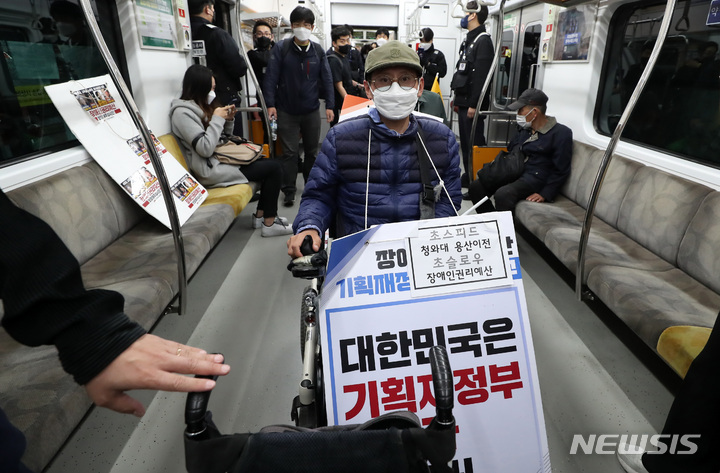 [서울=뉴시스] 이영환 기자 = 전국장애인차별철폐연대(전장연) 회원들이 지난달 21일 서울 종로구 지하철3호선 경복궁역에서 '출근길 지하철 타기' 시위를 하고 있다. 2022.04.21. 20hwan@newsis.com