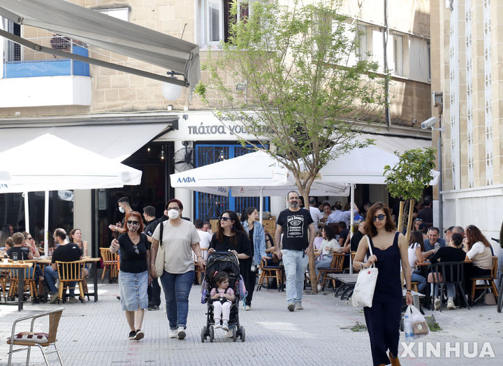 [신화/뉴시스] 키프로스의 수도 니코시아의 중심가에서 관광객과 주민들이 4월 22일 일부 마스크를 착용한 채 걷고 있다.&nbsp; 