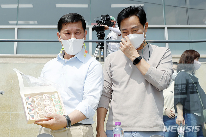 [서울=뉴시스] 최동준 기자 = 허구연 한국야구위원회 총재가 24일 서울 송파구 잠실야구장을 방문한 오세훈 서울시장과 경기 관람 전 한 야구팬에게 선물 받은 '야구 쿠키'를 들어 보이고 있다. 2022.04.24. photocdj@newsis.com
