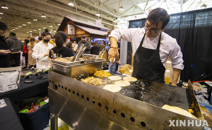 [ 토론토= 신화/뉴시스] 캐나다의 토론토에서 4월 24일 열린 세계 음식 페스티벌에서 150여개 부스의 셰프들이 조리를 하고 있다. 우크라이나 전쟁으로 세계 곡물시장의 가격이 급등하자 캐나다 정부는 세계 식량불안정의 해결사로 나서서 곡물 수출을 지원하기로 했다. 