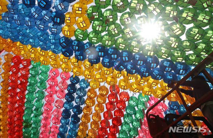 [서울=뉴시스] 조수정 기자 = 불기 2566년 부처님 오신날(5월8일)을 앞두고 27일 오후 서울 종로구 견지동 조계사 대웅전 앞마당에서 관계자가 오색 연등에 신도들의 소원지를 매달고 있다. 2022.04.27. chocrystal@newsis.com