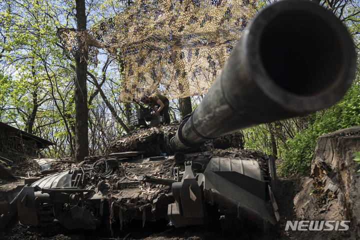 [도네츠크=AP/뉴시스] 지난달 27일(현지시간) 우크라이나 동부 도네츠크 지역에서 러시아군과 교전을 벌인 우크라이나 군인들이 정비 작업을 하면서 전차에 기관총을 설치하고 있다. 2022.05.03.