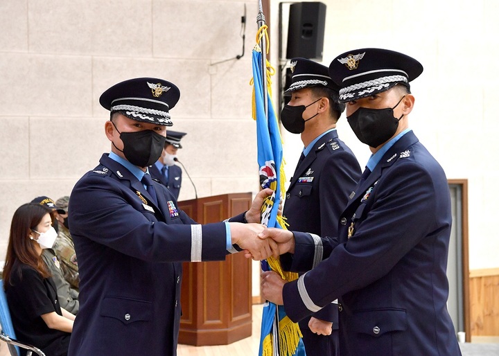 29일 공군 제38전투비행대에서 전대장 이성은 대령(왼쪽)이 신임 제111전투비행대대장 이동섭 중령(오른쪽)에게 대대기를 이양하고 있다. (사진=상사 유영임 제공) *재판매 및 DB 금지