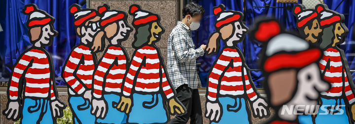 [서울=뉴시스] 정병혁 기자 = 정부가 내달 2일부터 실외 마스크 의무 착용 해제를 발표한 29일 오후 서울 강남구 삼성역 인근에서 마스크를 쓴 시민들이 마스크가 없는 캐릭터 사이로 지나가고 있다. 2022.04.29. jhope@newsis.com