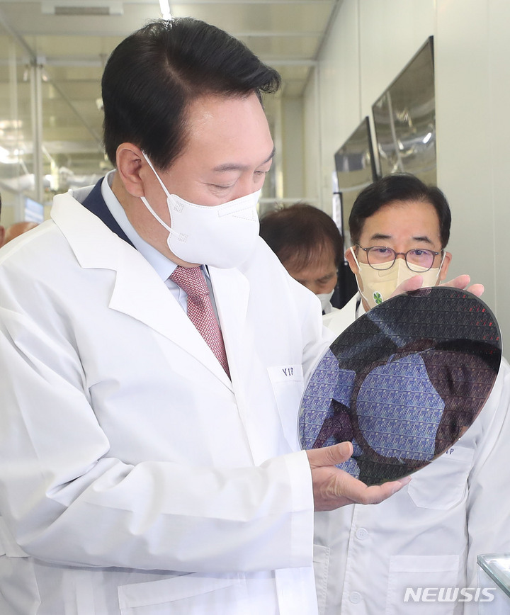 [대전=뉴시스] 인수위사진기자단 = 윤석열 대통령 당선인이 29일 오전 대전 한국과학기술원(KAIST) 내 나노종합기술원을 방문해 반도체 연구 현장을 둘러보던 중 반도체 웨이퍼 샘플을 살펴보고 있다. 2022.04.29. photo@newsis.com