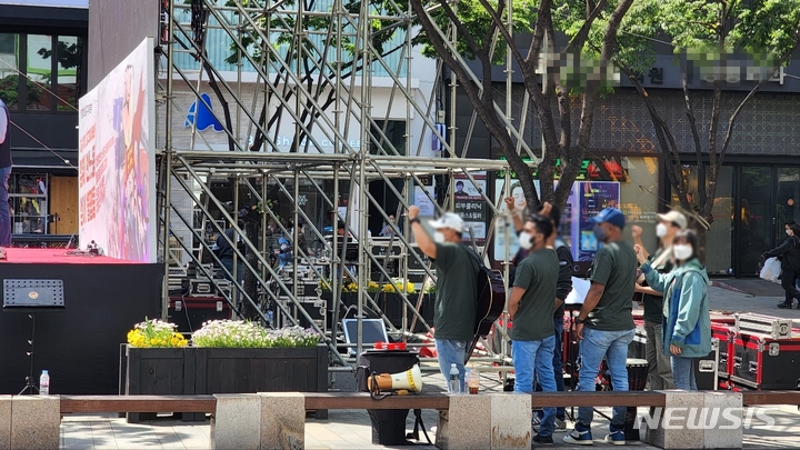 [대구=뉴시스] 이지연 기자 = 1일 오후 대구 중구 반월당 대중교통전용지구에서 열린 제132주년 세계노동절 대회 메인 무대 뒤에서 외국인 노동자들이 민중가요를 함께 부르고 있다. 2022.05.01. ljy@newsis.com