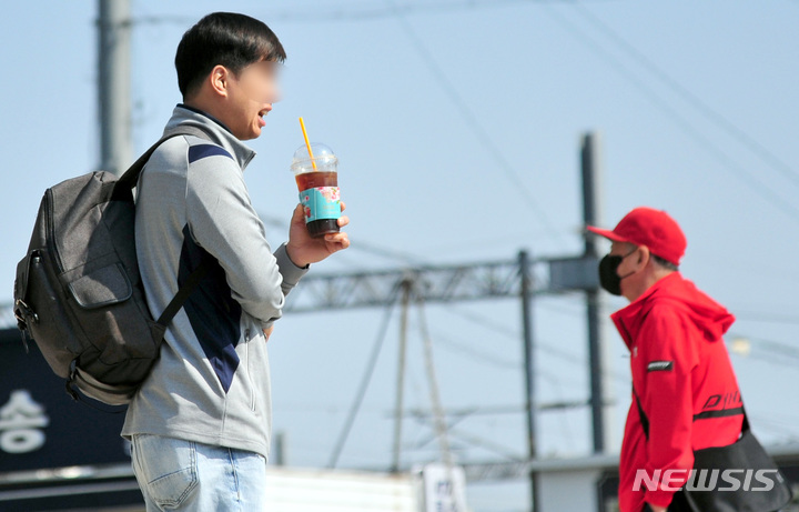 [광주=뉴시스] 이영주 기자 = 실외 마스크 착용 의무화가 해제된 2일 오전 광주 광산구 광주송정역 앞 광장에서 한 남성이 마스크를 벗은 채 음료수를 마시고 있다. 2022.05.02. leeyj2578@newsis.com