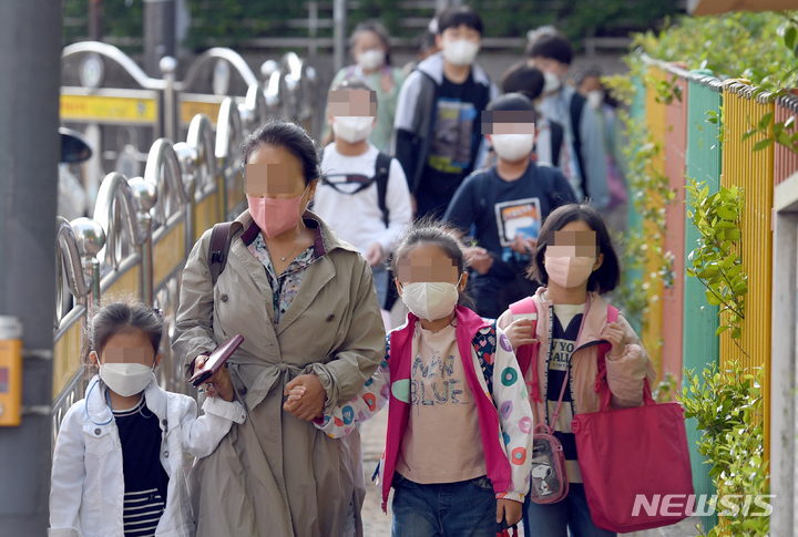 [광주=뉴시스] 류형근 기자 = 실외에서 마스크를 착용하지 않아도 되는 2일 오전 광주 남구 한 초등학교에서 학생들이 마스크를 착용한 채 등교하고 있다. 2022.05.02. hgryu77@newsis.com
