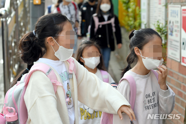 [광주=뉴시스] 류형근 기자 = 지난 2일 오전 광주 남구 한 초등학교 교문에서 일명 '턱스크'를 한채 등교했던 학생들이 마스크를 다시 쓰고 있다. 2022.05.02. hgryu77@newsis.com
